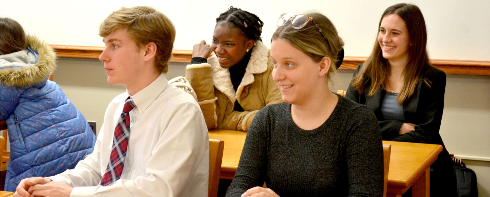 Students smile as they listen during a mock trial
