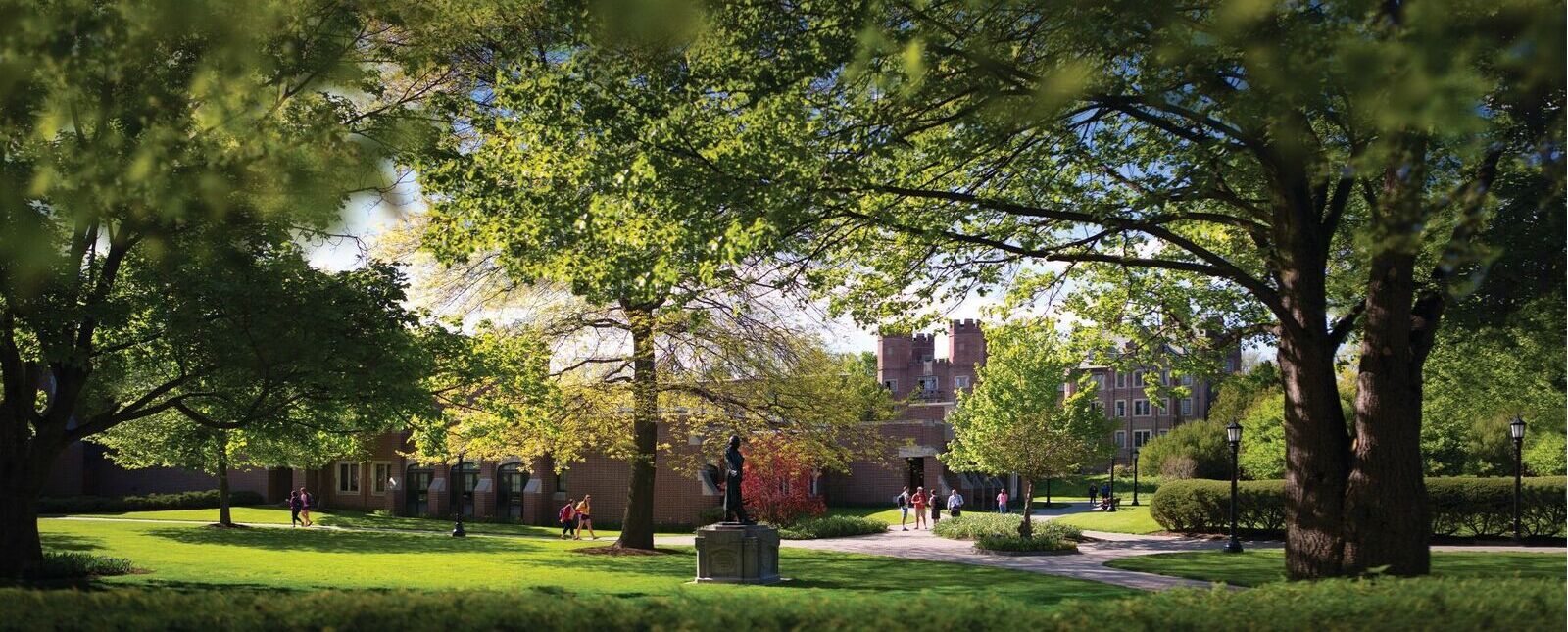 A greenspace of the Elmira College campus is surrounded by brick walkways and buildings