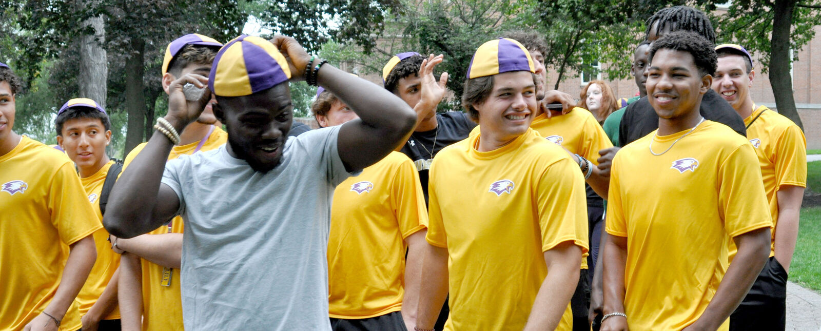 A male student adjusts his beanie while walking with others during the Fall Welcome