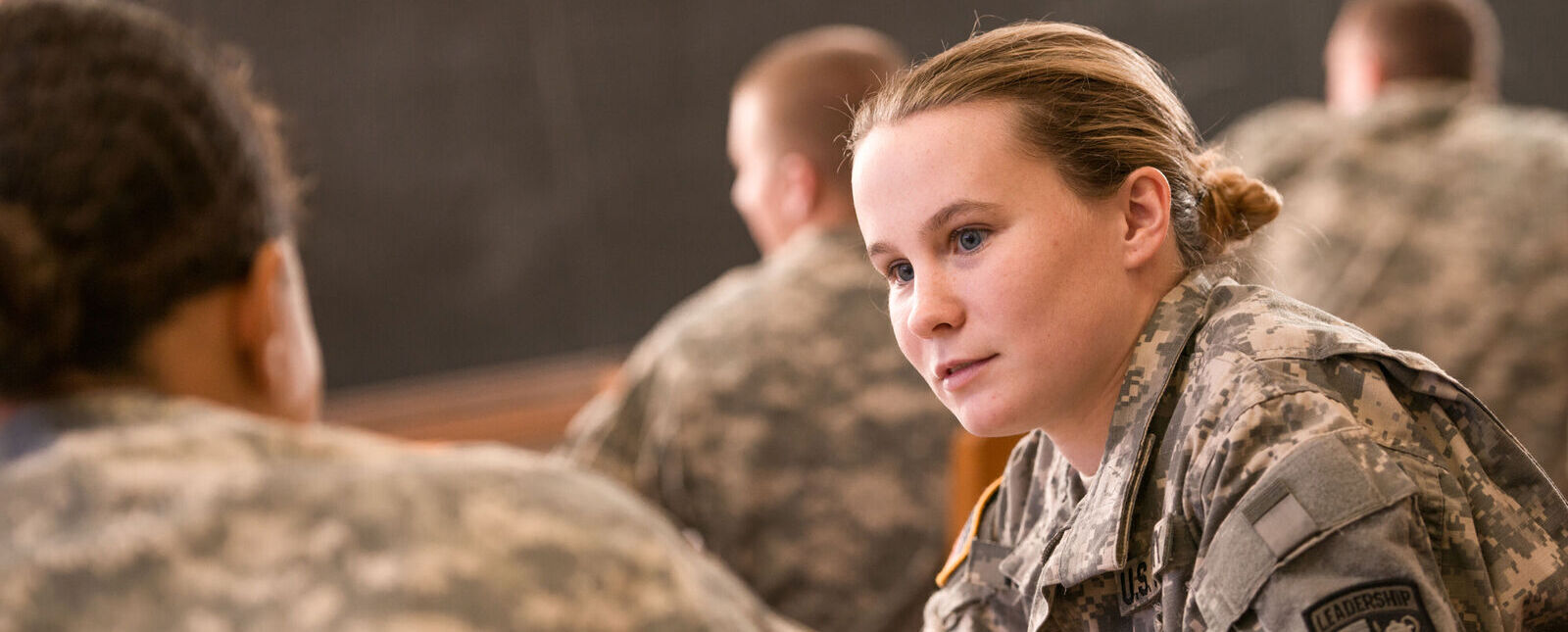 ROTC students speak with each other in a classroom