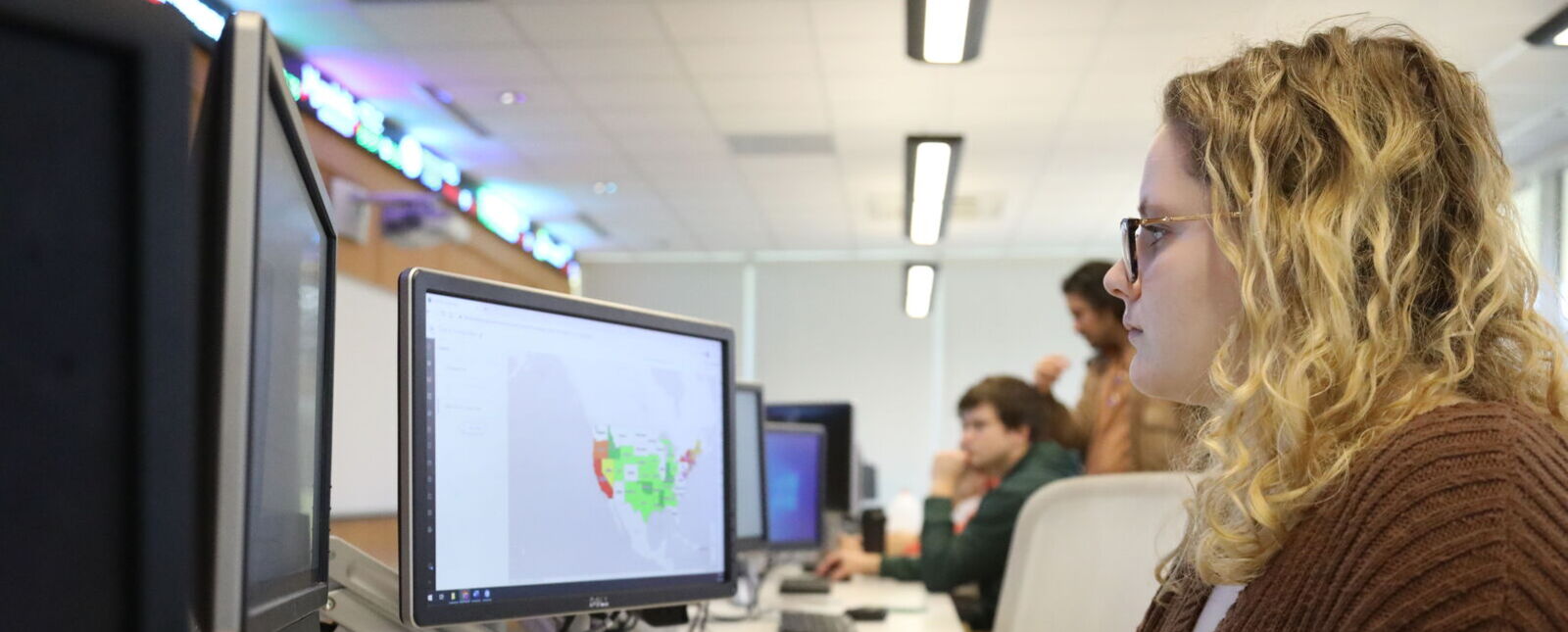 A student works on a computer in the Finance Trading Room during a Data Analytics course.