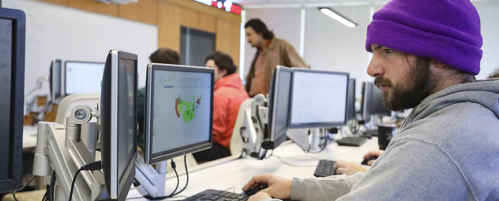 A student works on a computer with two monitors during a Data Analytics class