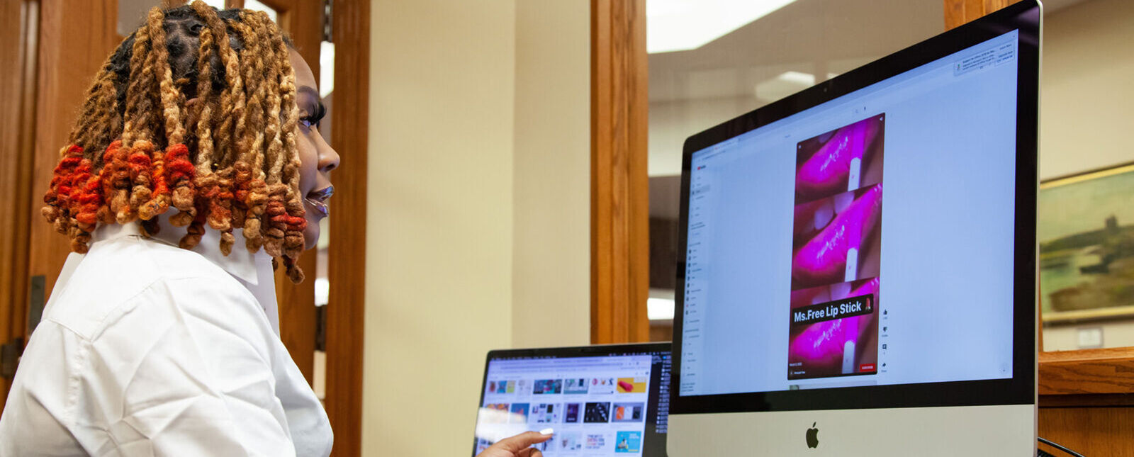 A female student works on a graphic design project on a computer