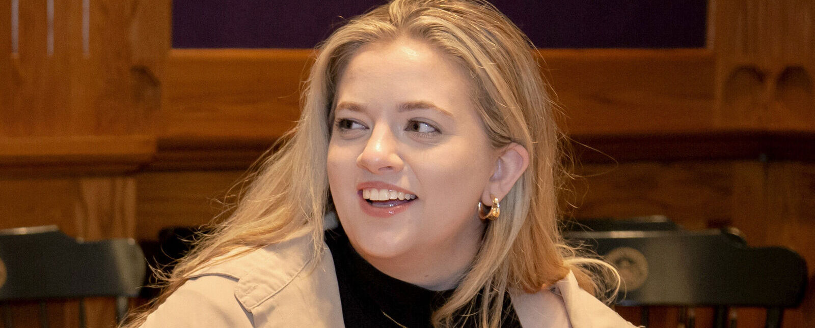 A female student smiles while working on a laptop