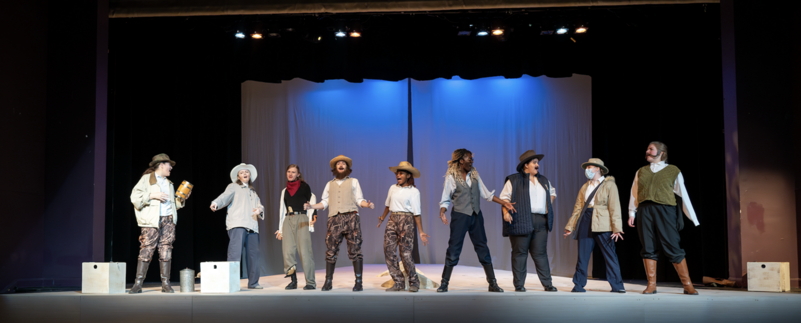 Students in costume stand on the Gibson stage as part of a Theatre performance.