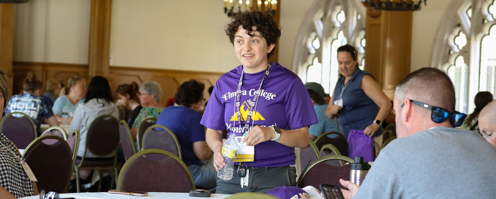 An orientation leader speaks with orientation attendees in a lecture hall