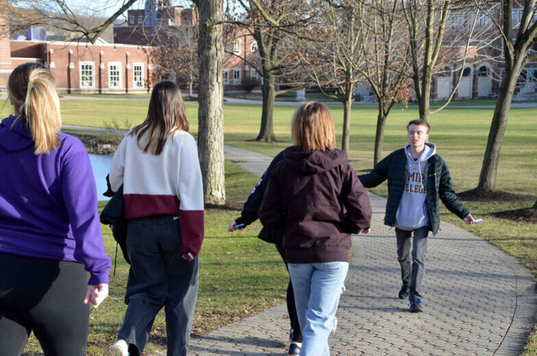A male student leads a tour of campus
