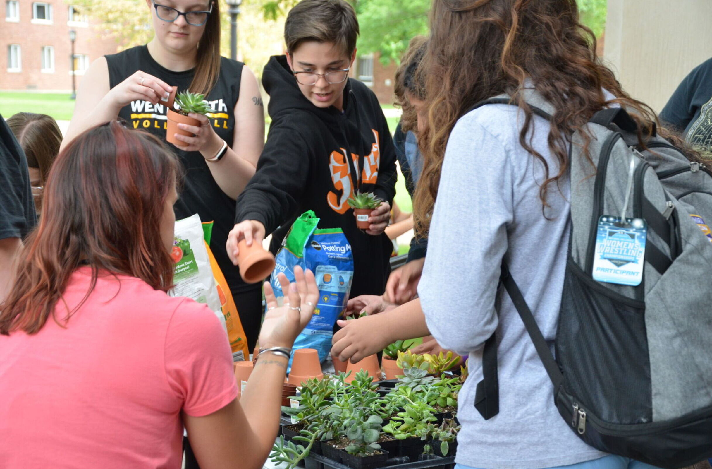 Students do a planting activity at the Environmental Club's table during the Club and Organizations Fair