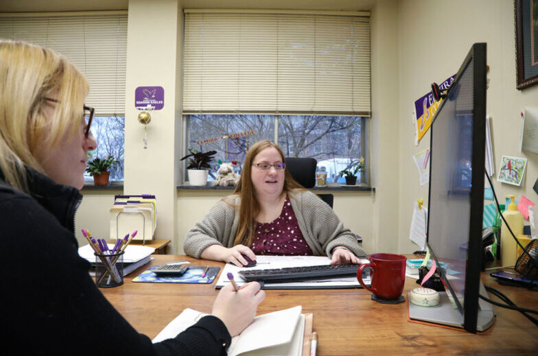 A Financial Aid counselor works with a student in an office