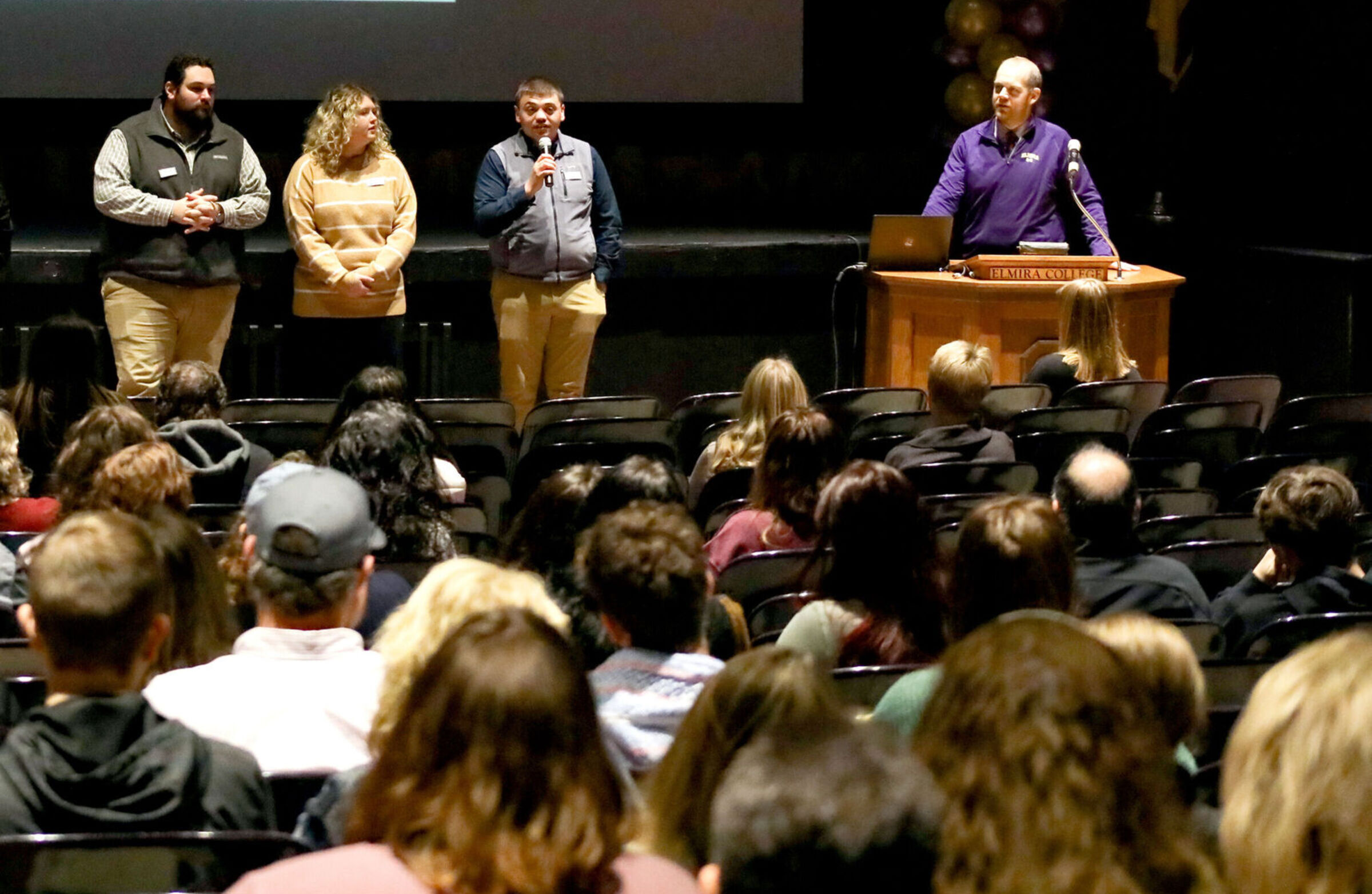 Admissions counselors speak with a crowd of guests in the Gibson Theatre