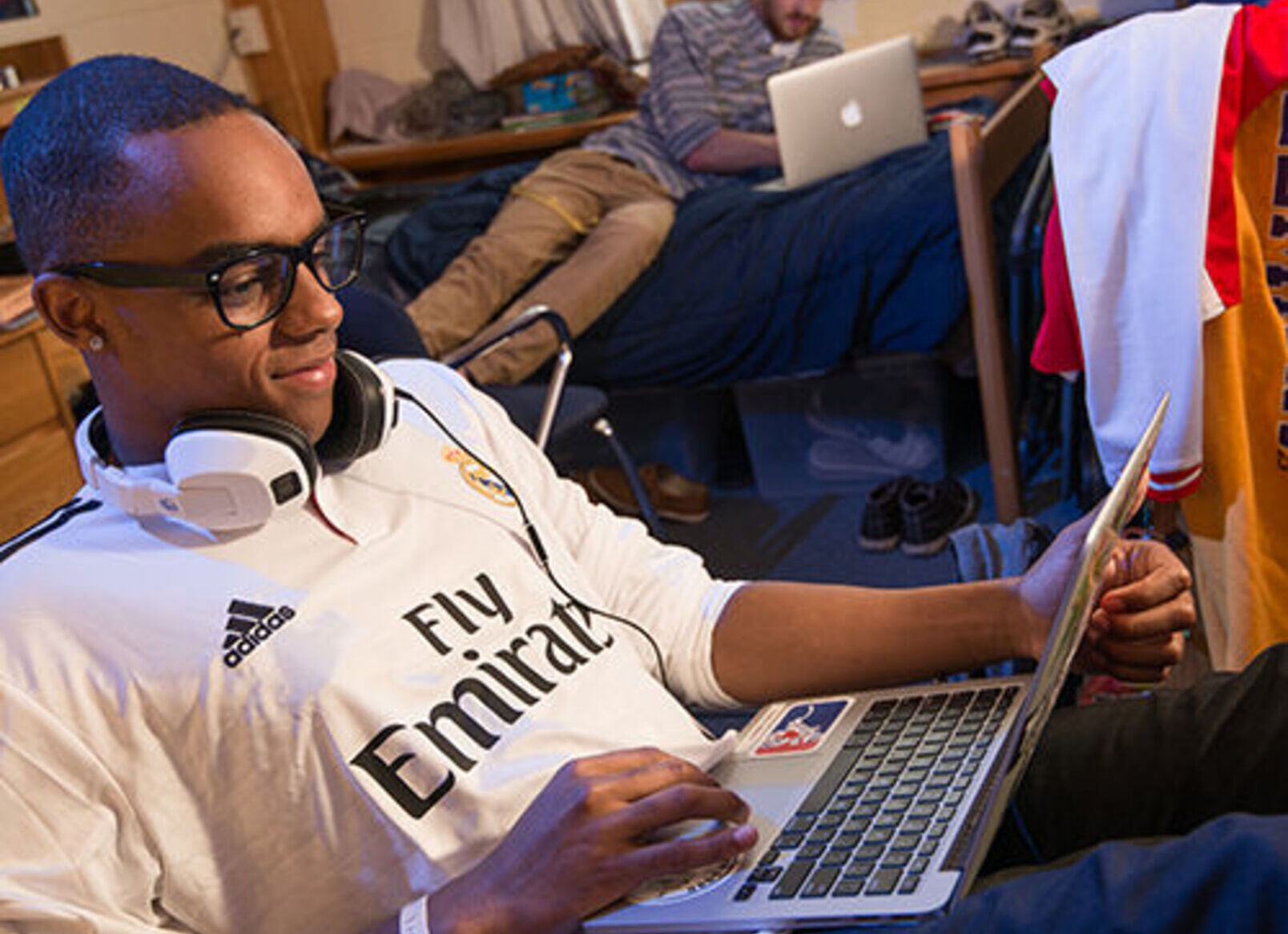 A student works on a laptop in a dorm room