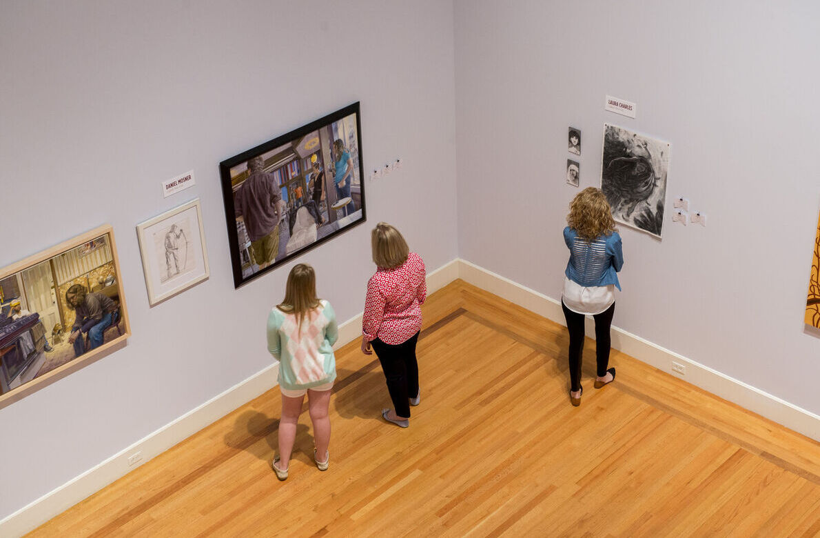 Visitors look at art on the walls of the Arnot Art Museum
