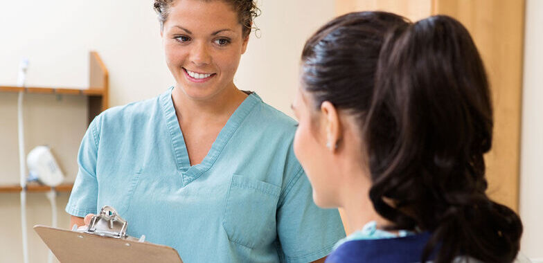 A female medical assistant speaks with a patient 