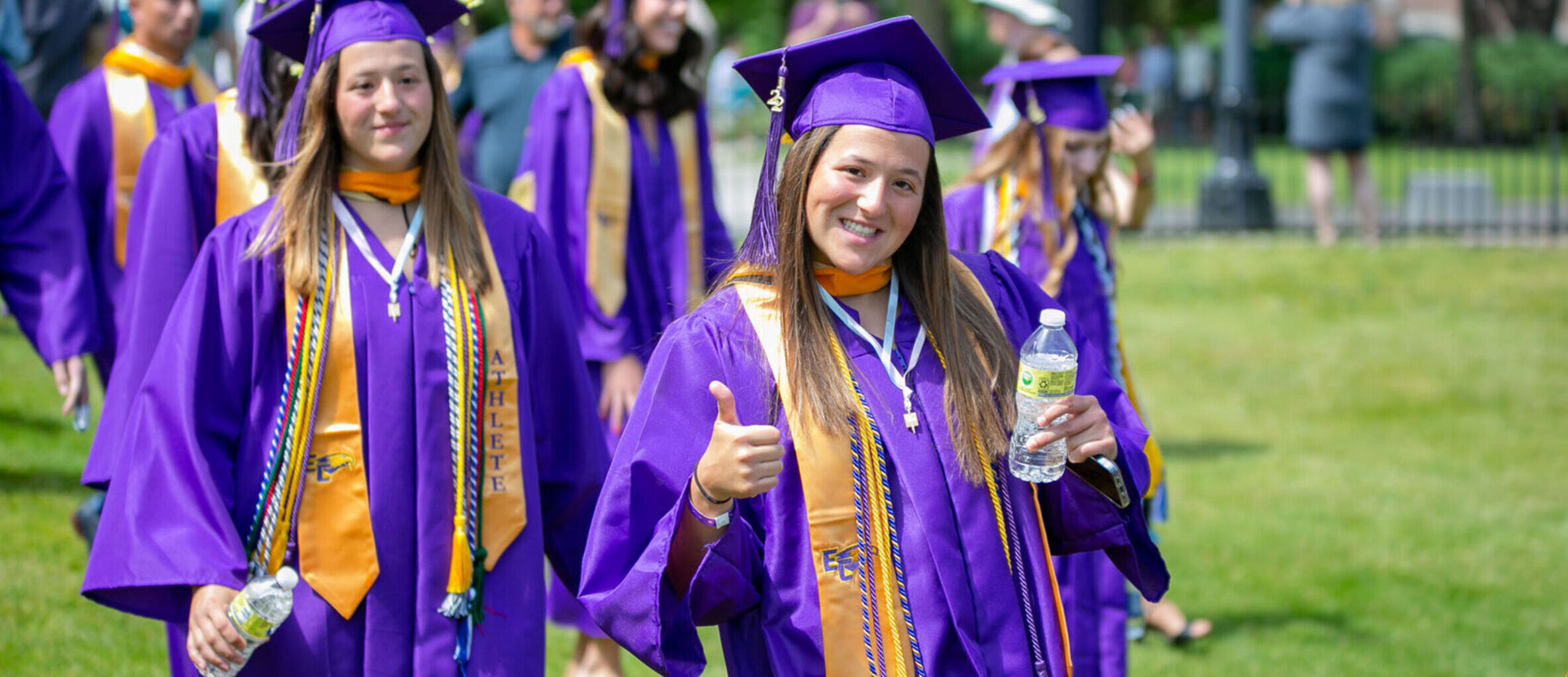 A student gives a thumbs up during commencement