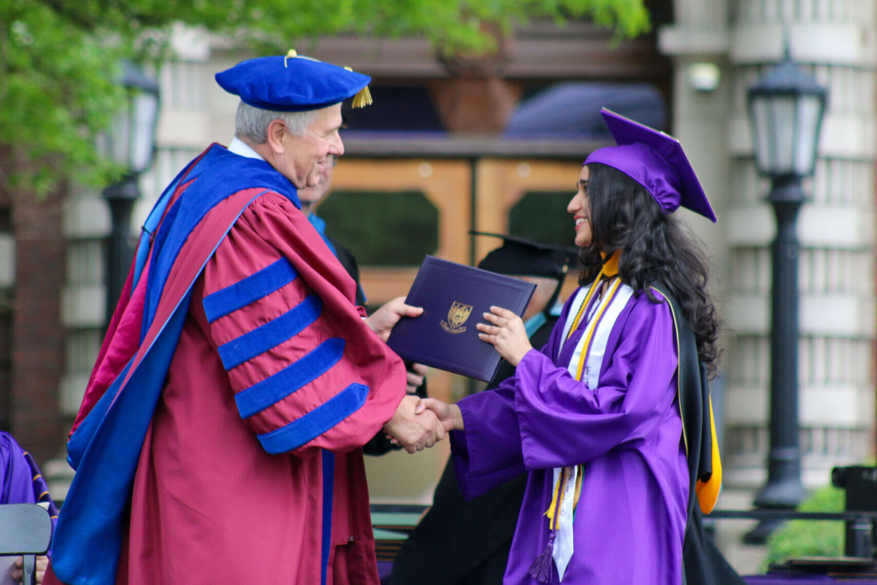 female student receives diploma from college president