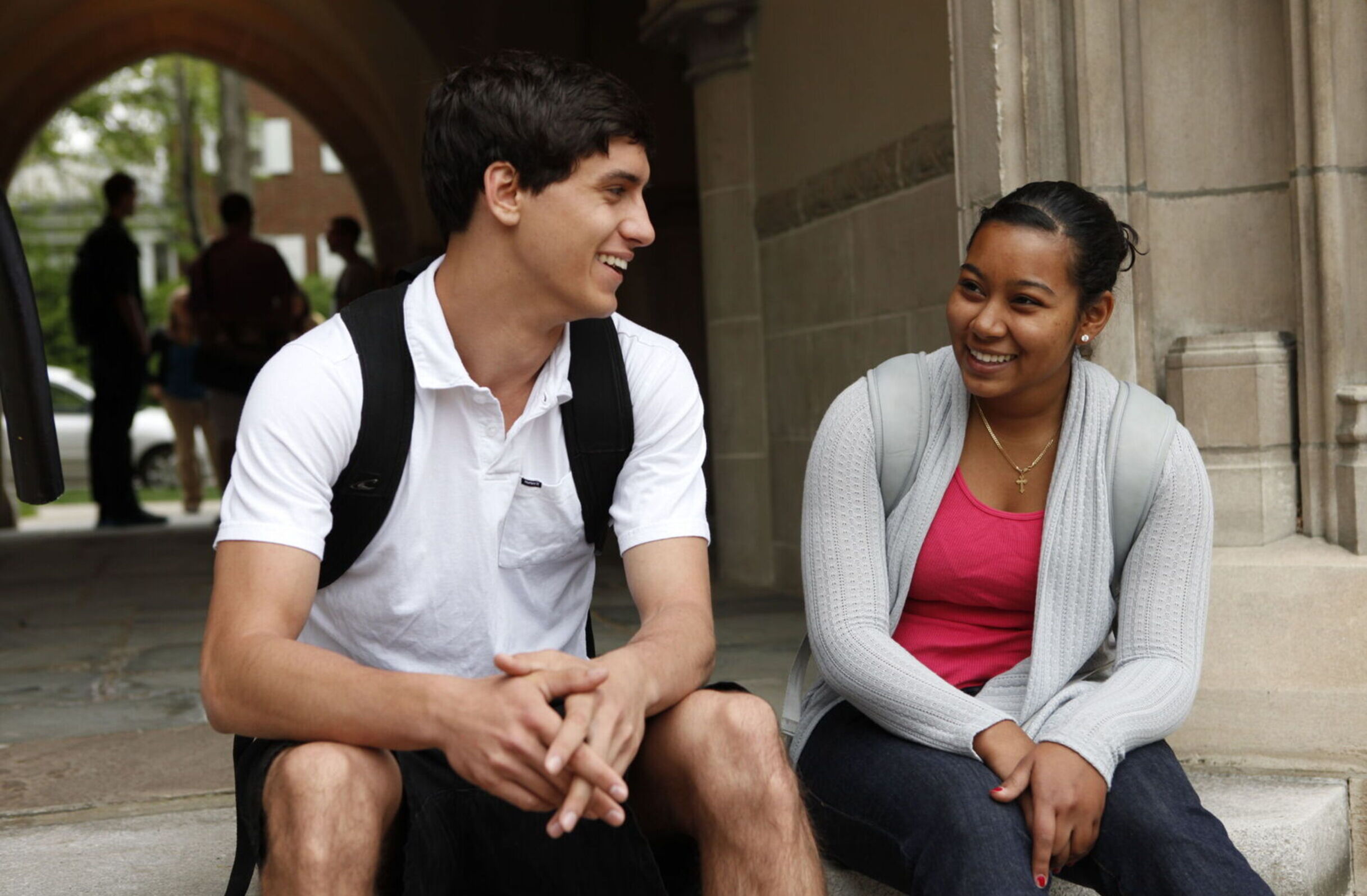 A male and female student talk on the steps of Meier Hall