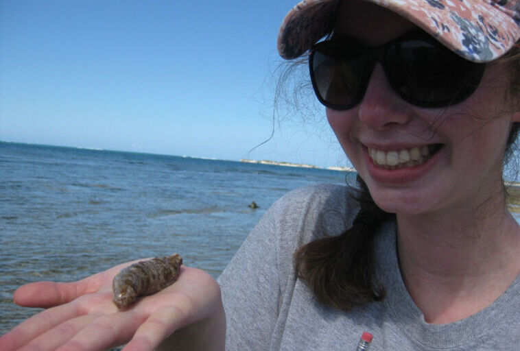 A student holds a sea cucumber while in the Bahamas