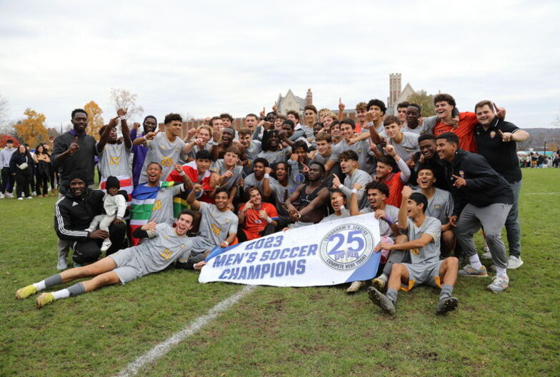 The Elmira College Men's Soccer Team poses with the Empire 8 Championship banner after their win
