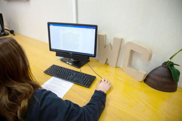 A student works on a writing project on a computer in the Writing Center