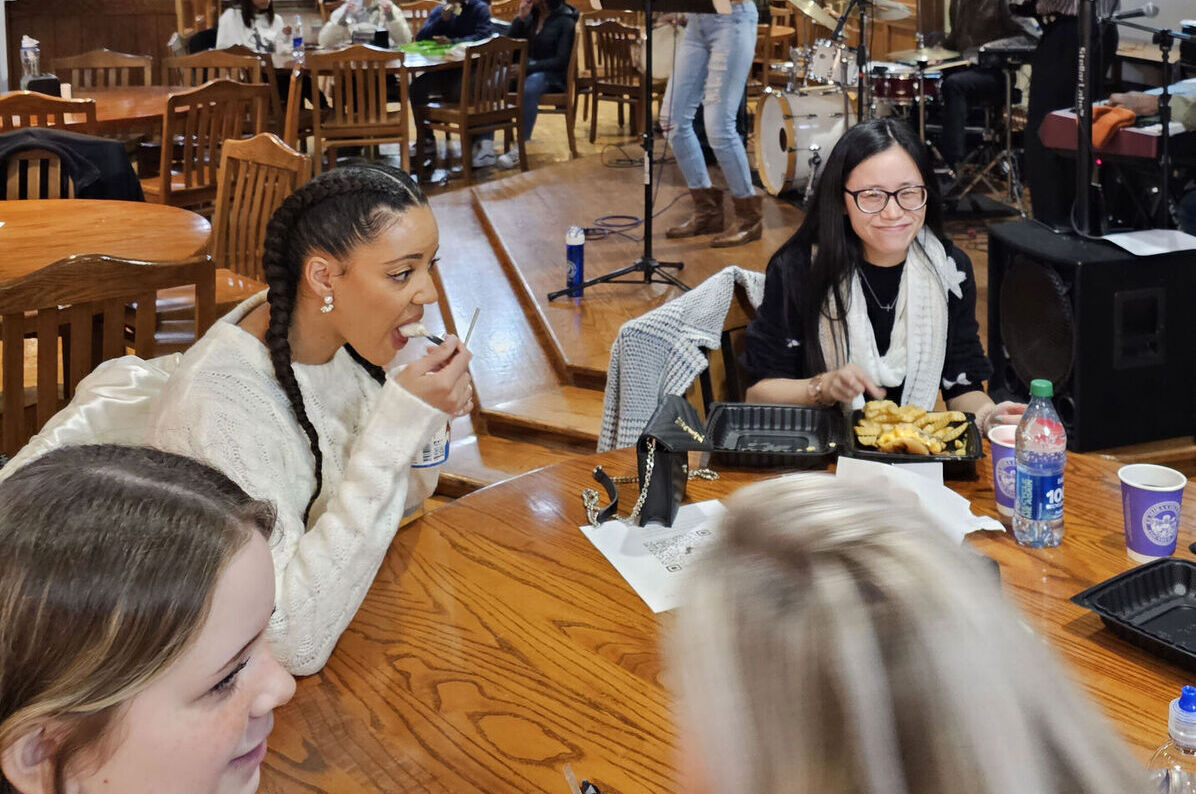Students talk and eat in MacKenzie's as a band plays in the background