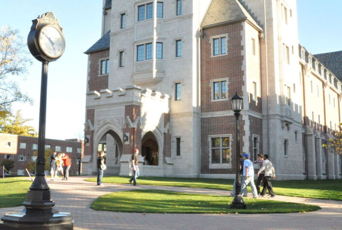 Students walk in front of Meier Hall on a fall day