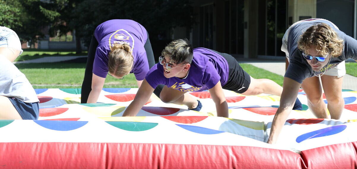 Students compete on a giant inflatable Twister board during the Mountain Day carnival