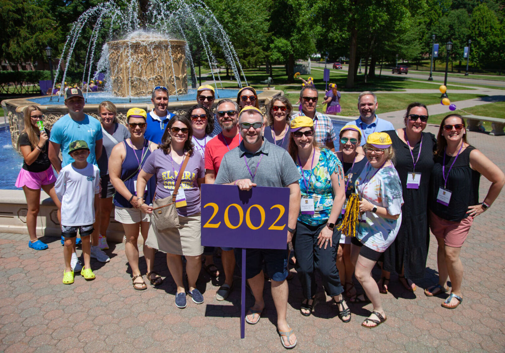 Members of the Class of 2022 pose with a 2002 sign during the alumni reunion parade