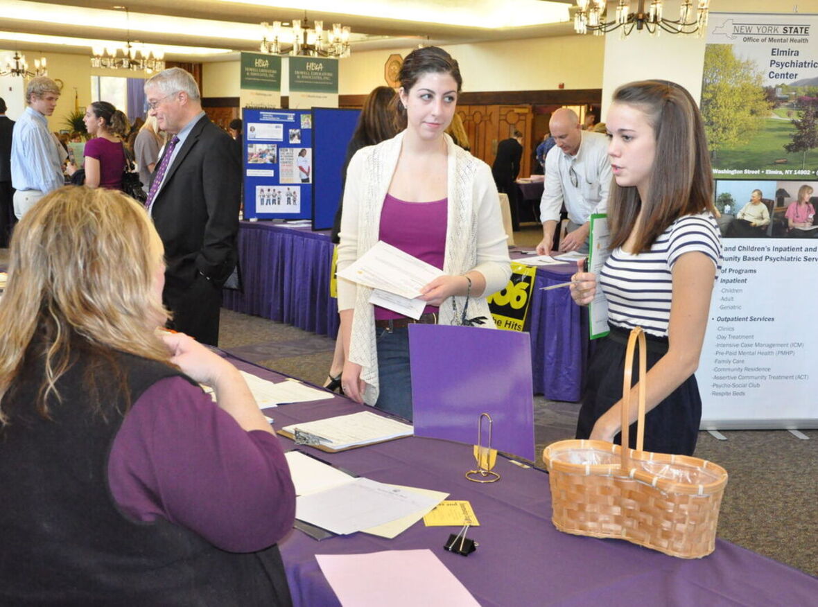 Two students meet with a recruiter at a job fair