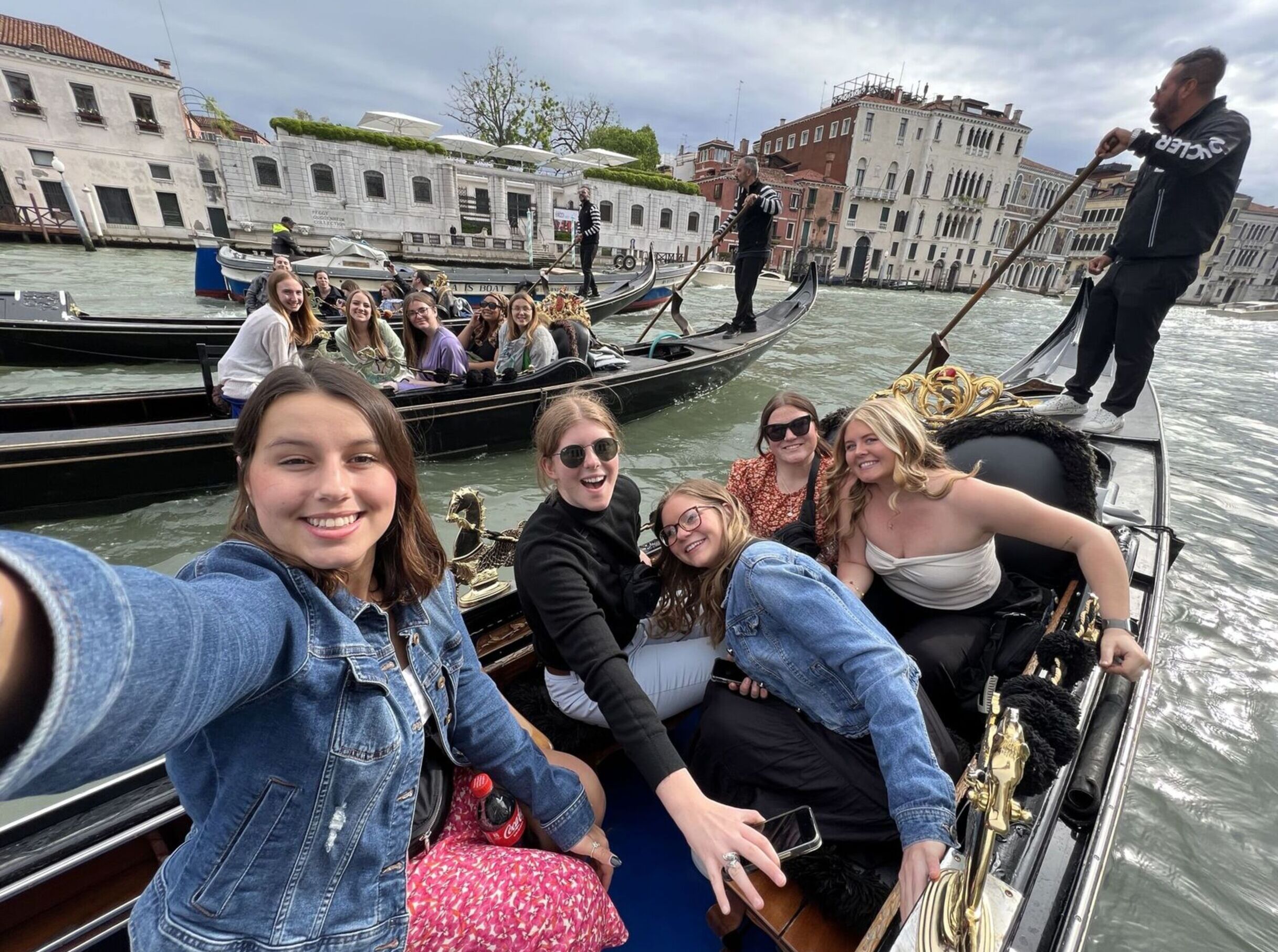 Education students pose for a selfie while riding multiple gondolas through Venice, Italy