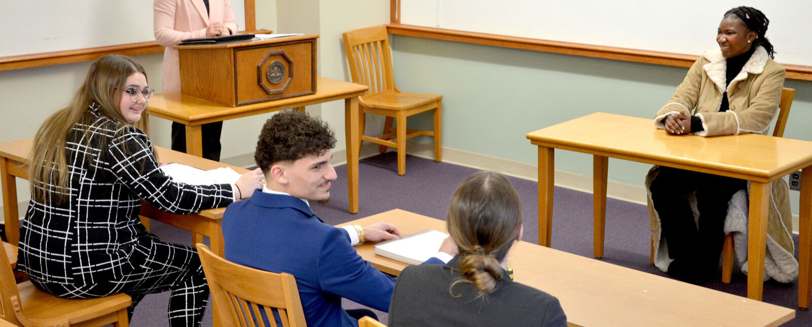 Students roleplay as lawyers and a witness during a mock trial.