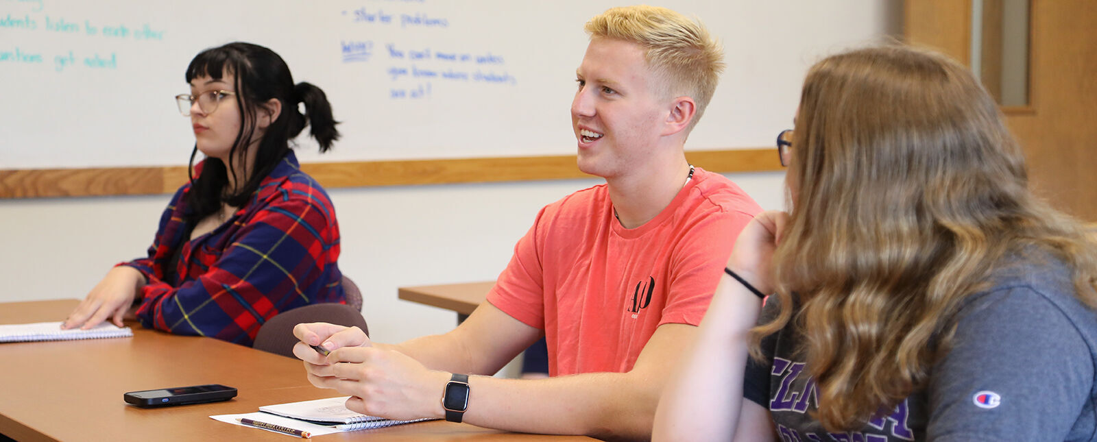 A male student smiles in a classroom