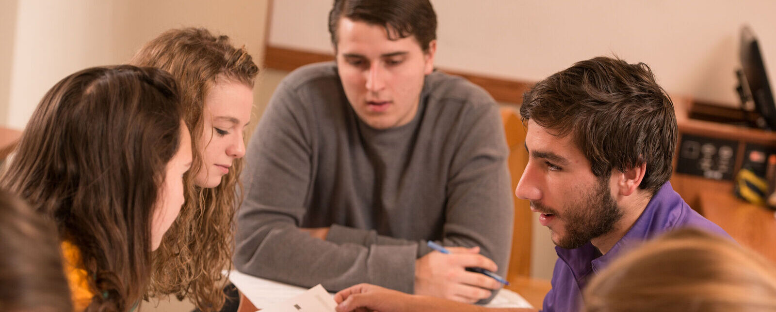 A group of students work together around a table