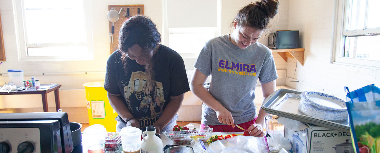 Two female students prepare fruit