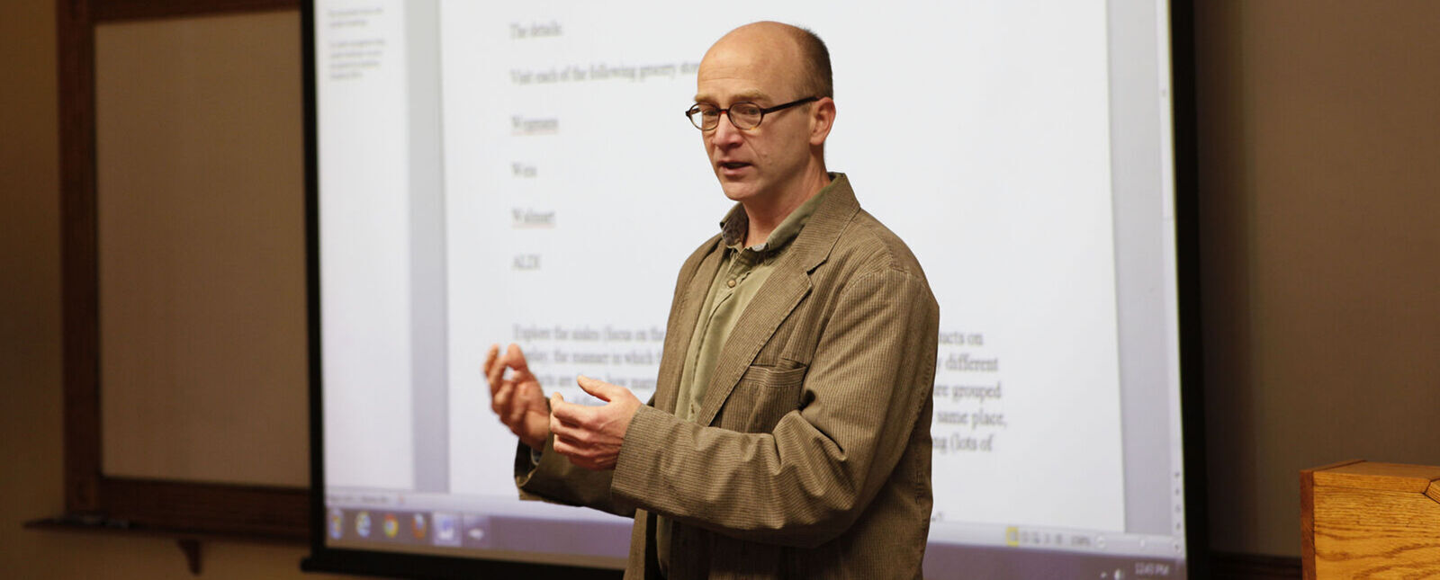 A professor conducts a lesson in front of a classroom